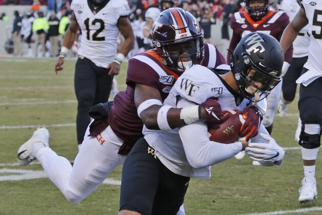 Wake Forest wide receiver Sage Surratt, right, heads to the end zone for a touchdown as Virginia Tech defensive back Devon Hunter (7) tries to make the stop during the first half of an NCAA collage football game in Blacksburg, Va., Saturday, Nov. 9, 2019. (AP Photo/Steve Helber)