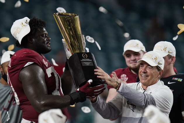Alabama head coach Nick Saban and offensive lineman Alex Leatherwood hold the trophy after their win against Ohio State in an NCAA College Football Playoff national championship game, Tuesday, Jan. 12, 2021, in Miami Gardens, Fla. Alabama won 52-24. (AP Photo/Chris O'Meara)