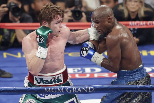 Canelo Alvarez, left, throws a punch against Floyd Mayweather Jr. during a 152-pound title fight, Saturday, Sept. 14, 2013, in Las Vegas. (AP Photo/Isaac Brekken)