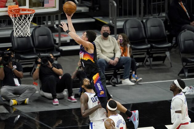 Phoenix Suns guard Devin Booker (1) is fouled by Los Angeles Clippers guard Paul George during the second half of an NBA basketball game, Wednesday, April 28, 2021, in Phoenix. (AP Photo/Matt York)