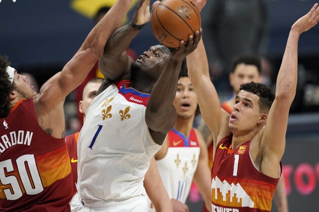 New Orleans Pelicans forward Zion Williamson (1) drives to the rim between Denver Nuggets forwards Aaron Gordon (50) and Michael Porter Jr., right, in the second half of an NBA basketball game Wednesday, April 28, 2021, in Denver. The Nuggets held on to win 114-112. (AP Photo/David Zalubowski)