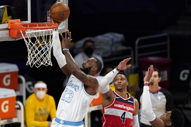 Los Angeles Lakers forward LeBron James, left, shoots as Washington Wizards guard Russell Westbrook, center, and forward Rui Hachimura defend during the first half of an NBA basketball game Monday, Feb. 22, 2021, in Los Angeles. (AP Photo/Mark J. Terrill)