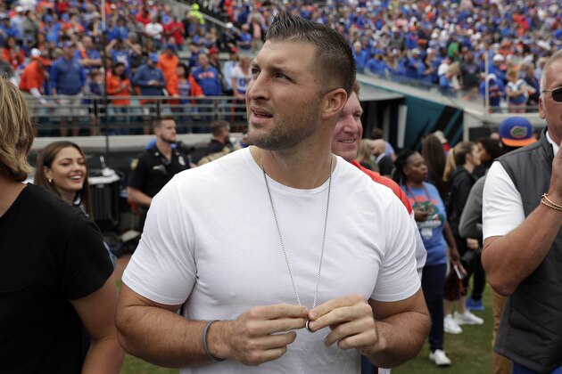 Former Florida quarterback and NFL player Tim Tebow looks up at the scoreboard during the first half of an NCAA college football game between Florida and Georgia, Saturday, Nov. 2, 2019, in Jacksonville, Fla. (AP Photo/John Raoux)