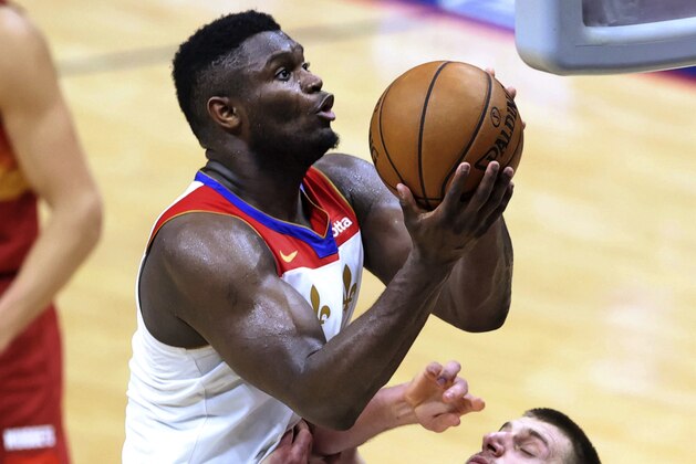 New Orleans Pelicans forward Zion Williamson (1) drives to the basket as Denver Nuggets center Nikola Jokic defends during the second half of an NBA basketball game in New Orleans, Friday, March 26, 2021. (AP Photo/Rusty Costanza)