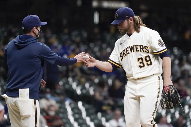 Milwaukee Brewers manager Craig Counsell takes starter Corbin Burnes out of the game during the sixth inning of a baseball game against the Miami Marlins Monday, April 26, 2021, in Milwaukee. (AP Photo/Morry Gash)