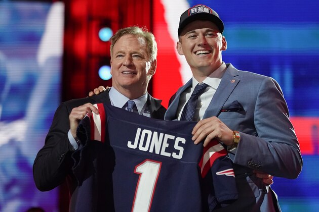 Alabama quarterback Mac Jones, right, holds a team jersey with NFL Commissioner Roger Goodell after the New England Patriots selected him with the 15th pick in the NFL football draft, Thursday April 29, 2021, in Cleveland. (AP Photo/Tony Dejak)