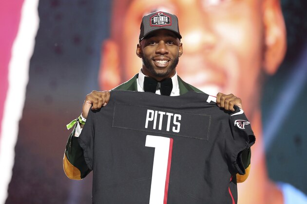 Florida tight end Kyle Pitts, right, holds a team jersey after the Atlanta Falcons selected Pitts with the 4th pick in the first round of the NFL football draft Thursday April 29, 2021, in Cleveland. (AP Photo/Gregory Payan)