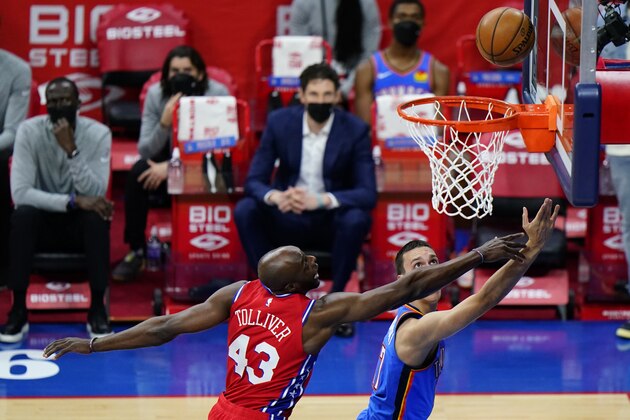Oklahoma City Thunder's Aleksej Pokusevski, right, goes up for a shot past Philadelphia 76ers' Anthony Tolliver during the first half of an NBA basketball game, Monday, April 26, 2021, in Philadelphia. (AP Photo/Matt Slocum)