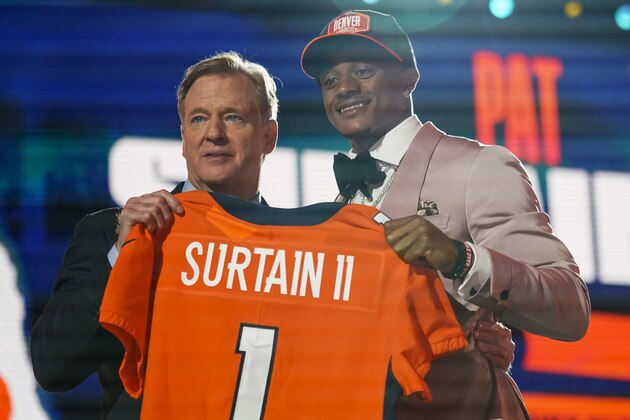 Alabama cornerback Patrick Surtain II, right, holds a team jersey with NFL Commissioner Roger Goodell after he was chosen by the Denver Broncos with the ninth pick in the NFL football draft, Thursday, April 29, 2021, in Cleveland. (AP Photo/Tony Dejak)