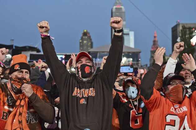 Cleveland Browns fans celebrate the second round pick, Jeremiah Owusu-Koramoah, linebacker for Notre Dame, at the NFL football draft, Friday, April 30, 2021, in Cleveland. (AP Photo/David Dermer)