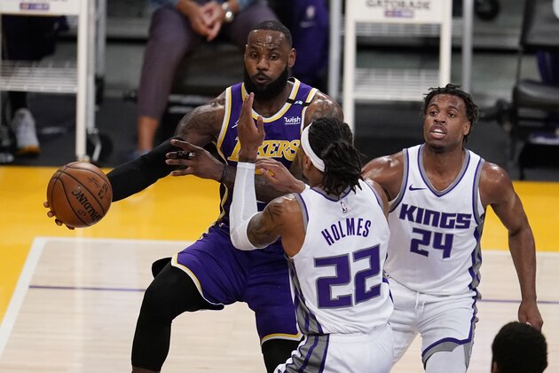 Los Angeles Lakers forward LeBron James, left, passes the ball past Sacramento Kings center Richaun Holmes (22) during the first half of an NBA basketball game Friday, April 30, 2021, in Los Angeles. (AP Photo/Marcio Jose Sanchez)
