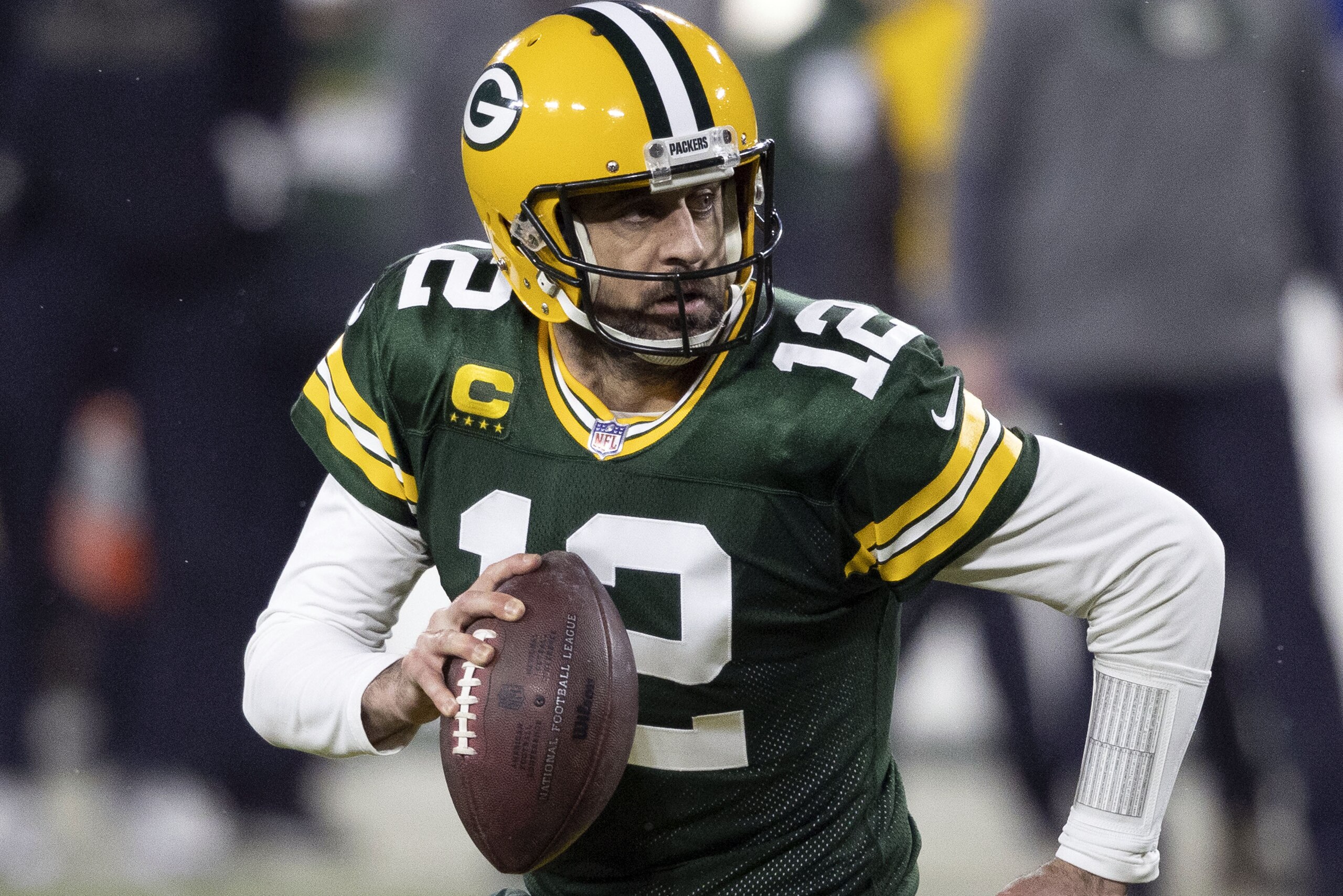 ARCHIVO - En esta foto de archivo del 16 de enero de 2021, Aaron Rodgers, quarterback de los Packers de Green Bay, acarrea el balón durante un partido de playoffs ante los Rams de Los Ángeles (AP Foto/Jeffrey Phelps, archivo)