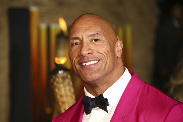 FILE - In this Dec. 5, 2019 file photo, actor Dwayne Johnson poses for photographers upon arrival at the premiere of the film 'Jumanji The Next Level', in central London.   Johnson will revisit his younger years in a new NBC comedy series called “The Rock,” which is the retired pro wrestler's nickname. NBC said Saturday, Jan. 11, 2020  that it's ordered 11 episodes of the show inspired by Johnson, who will appear and also serve as an executive producer.  (Photo by Joel C Ryan/Invision/AP)