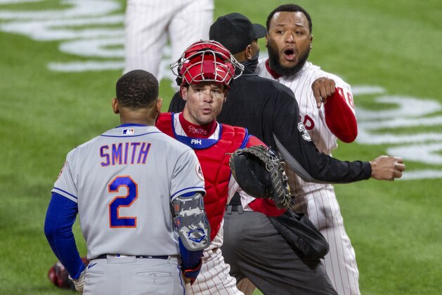 Philadelphia Phillies relief pitcher Jose Alvarado, right, has an altercation with New York Mets' Dominic Smith (2) as catcher Andrew Knapp tries to intervene after Smith struck out swinging in the eighth inning of a baseball game, Friday, April 30, 2021, in Philadelphia. (AP Photo/Laurence Kesterson)