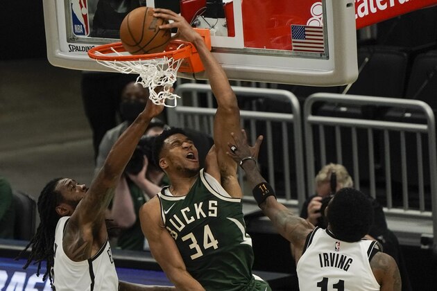 Milwaukee Bucks' Giannis Antetokounmpo dunks in front of Brooklyn Nets' DeAndre Jordan during the first half of an NBA basketball game Sunday, May 2, 2021, in Milwaukee. (AP Photo/Morry Gash)