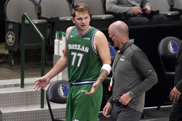 Dallas Mavericks guard Luka Doncic (77) talks with a team staff member as he walks off the court after being ejected late in the second half of an NBA basketball game against the Sacramento Kings in Dallas, Sunday, May 2, 2021. (AP Photo/Tony Gutierrez)