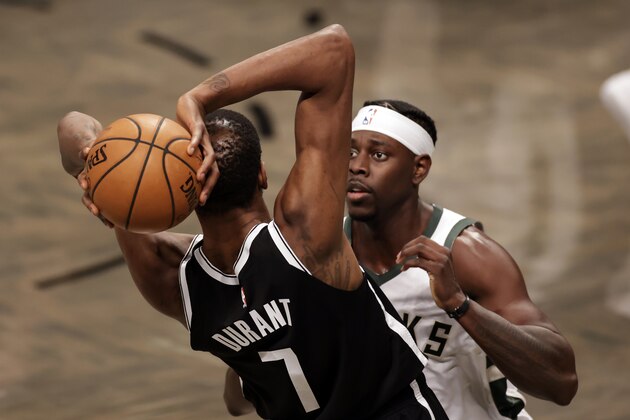 Milwaukee Bucks guard Jrue Holiday (21) defends Brooklyn Nets forward Kevin Durant (7) during an NBA basketball game Monday, Jan. 18, 2021, in New York. The Nets won 123-125. (AP Photo/Adam Hunger)