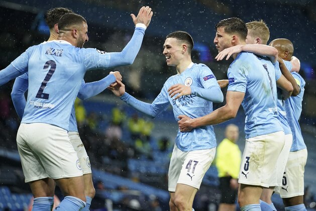 Manchester City's Riyad Mahrez celebrates with teammates after scoring his sides second goal during the Champions League semifinal second leg soccer match between Manchester City and Paris Saint Germain at the Etihad stadium, in Manchester, Tuesday, May 4, 2021. (AP Photo/Dave Thompson)