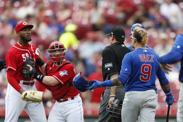 Chicago Cubs' Javier Baez (9) has a few words for Cincinnati Reds relief pitcher Amir Garrett, far left, after striking out during the seventh inning in the first baseball game of a doubleheader, Saturday, May 19, 2018, in Cincinnati. (AP Photo/Gary Landers)