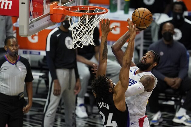 Los Angeles Clippers forward Paul George, right, shoots over Toronto Raptors center Khem Birch (24) during the first half of an NBA basketball game Tuesday, May 4, 2021, in Los Angeles. (AP Photo/Marcio Jose Sanchez)