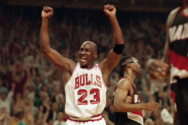 FILE - In this June 14, 1992, file photo, Michael Jordan celebrates the Bulls win over the Portland Trail Blazers in the NBA Finals in Chicago. Decades after Jordan's groundbreaking departure from college, March Madness and the NBA's mega-millions have taken all the novelty out of leaving early for the pros. (AP Photo/John Swart, File)