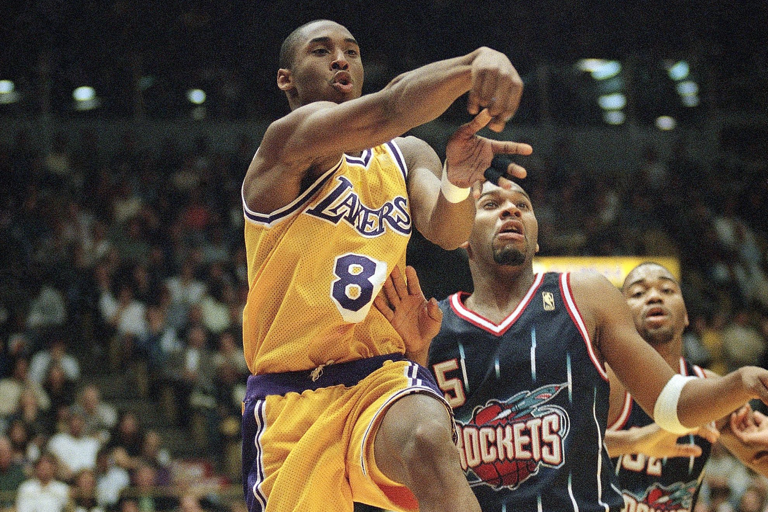 Los Angeles Laker guard Kobe Bryant (8) passes to a teammate under the basket as Houston Rockets, Sam Mack looks on during the first half at the Forum in Inglewood, California on Friday, March 7, 1997. (AP Photo/E. J. Flynn) Los Angeles Laker guard Kobe Bryant (8) passes to a teammate under the basket as Houston Rockets, Sam Mack looks on during the first half at the Forum in Inglewood, California on Friday, March 7, 1997. (AP Photo/E. J. Flynn)