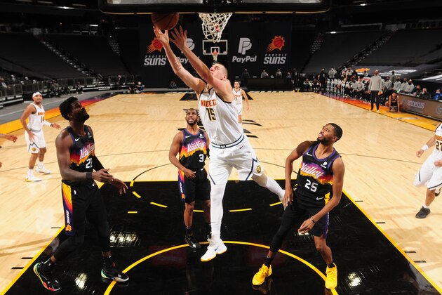 Phoenix Suns guard Chris Paul, right, looks to pass the ball as Denver Nuggets center Nikola Jokic, front left, and guard Jamal Murray defend during the first half of an NBA basketball game Friday, Jan. 1, 2021, in Denver. (AP Photo/David Zalubowski)