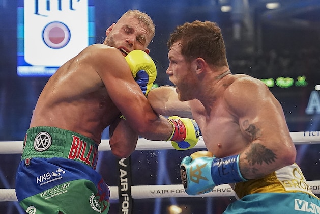 Canelo Alvarez, right, connects against Billy Joe Saunders during a unified super middleweight world championship boxing match, Saturday, May 8, 2021, in Arlington, Texas.(AP Photo/Jeffrey McWhorter)