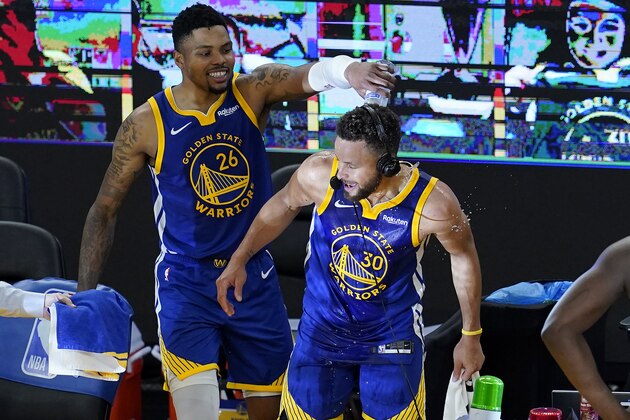 Golden State Warriors forward Kent Bazemore, left, pours water onto guard Stephen Curry (30) after the Warriors defeated the Denver Nuggets in an NBA basketball game in San Francisco, Monday, April 12, 2021. (AP Photo/Jeff Chiu)