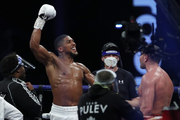 World Heavyweight boxing champion Britain's Anthony Joshua celebrates after beating challenger Bulgaria's Kubrat Pulev in their Heavyweight title fight at Wembley Arena in London Saturday, Dec. 12, 2020. (Andrew Couldridge/Pool via AP) World Heavyweight boxing champion Britain's Anthony Joshua celebrates after beating challenger Bulgaria's Kubrat Pulev in their Heavyweight title fight at Wembley Arena in London Saturday, Dec. 12, 2020. (Andrew Couldridge/Pool via AP)