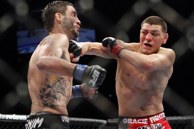 Nick Diaz , right, trades punches with Carlos Condit during their UFC interim welterweight mixed martial arts title match, Saturday, Feb. 4, 2012 at The Mandalay Bay Resort & Casino in Las Vegas. Condit won by unanimous decision. (AP Photo/Eric Jamison)