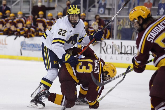 Michigan's Owen Power (22) and Minnesota's Cullen Munson (13) battle during an NCAA hockey game on Wednesday Dec. 8, 2020, in Ann Arbor, Mich. Minnesota won 3-1. (AP Photo/Al Goldis)