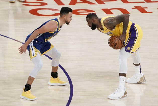 Golden State Warriors' Stephen Curry, left, pressures Los Angeles Lakers' LeBron James during the first half of an NBA basketball game, Monday, Jan. 18, 2021, in Los Angeles. (AP Photo/Jae C. Hong)