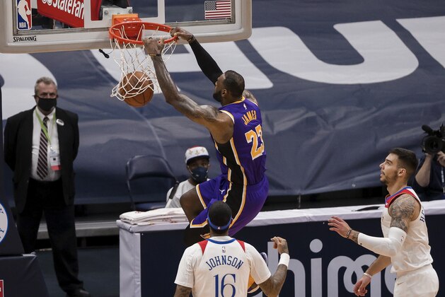 Los Angeles Lakers forward LeBron James (23) dunks over New Orleans Pelicans forward James Johnson (16) and center Willy Hernangomez (9) in the third quarter of an NBA basketball game in New Orleans, Sunday, May 16, 2021. (AP Photo/Derick Hingle)