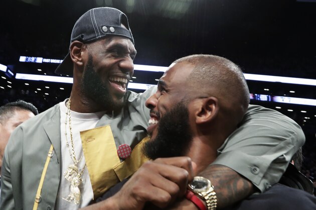 LeBron James embraces Chris Paul following an NBA basketball game between the Brooklyn Nets and the Miami Heat, Wednesday, April 10, 2019, in New York. The pair, along with Carmelo Anthony, were in New York to watch Dwyane Wade's final NBA game. (AP Photo/Kathy Willens)