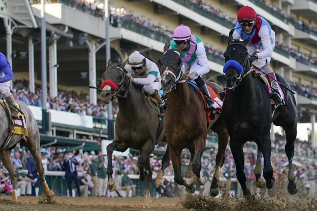 John Velazquez riding Medina Spirit, right, leads Florent Geroux on Mandaloun, Flavien Prat riding Hot Rod Charlie and Luis Saez on Essential Quality to win the 147th running of the Kentucky Derby at Churchill Downs, Saturday, May 1, 2021, in Louisville, Ky. (AP Photo/Jeff Roberson)