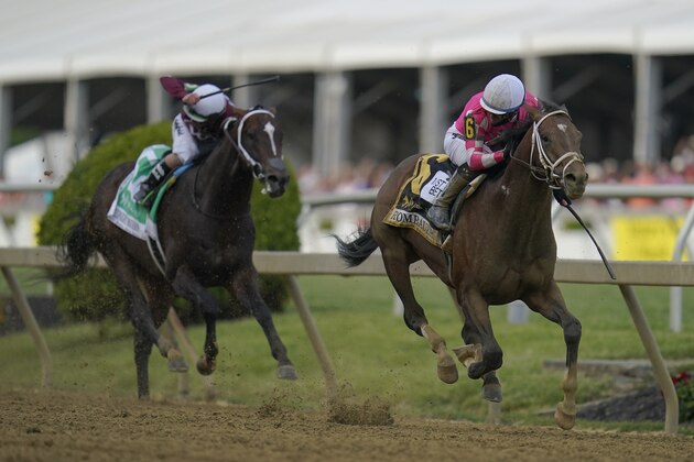 Flavien Prat atop Rombauer, right, looks back as he breaks away from Irad Ortiz Jr. atop Midnight Bourbon moments before crossing the finish line to win the Preakness Stakes horse race at Pimlico Race Course, Saturday, May 15, 2021, in Baltimore. (AP Photo/Julio Cortez)