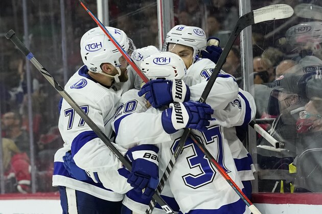 Tampa Bay Lightning defenseman Victor Hedman (77), center Yanni Gourde (37) and center Blake Coleman (20) congratulate center Barclay Goodrow, right, following Goodrow's goal during the third period in Game 1 of an NHL hockey Stanley Cup second-round playoff series against the Carolina Hurricanes in Raleigh, N.C., Sunday, May 30, 2021. (AP Photo/Gerry Broome)