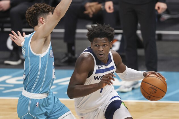 Minnesota Timberwolves forward Anthony Edwards, right, drives past Charlotte Hornets guard LaMelo Ball during the first half of an NBA basketball game in Charlotte, N.C., Friday, Feb. 12, 2021. (AP Photo/Nell Redmond)