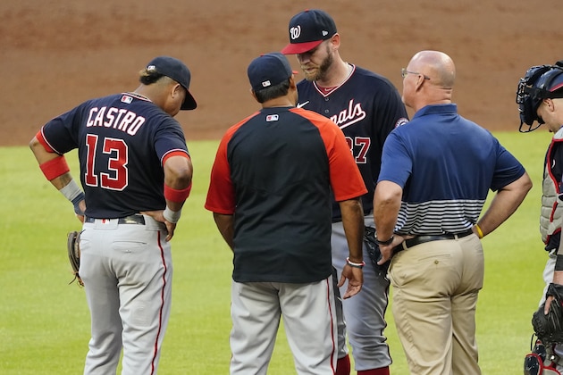 Washington Nationals starting pitcher Stephen Strasburg, center, talks with manager Dave Martinez and a member of the team's medical staff before exiting a baseball game in then second inning against Atlanta Braves Tuesday, June 1, 2021, in Atlanta. (AP Photo/John Bazemore)