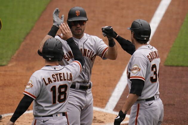 San Francisco Giants' Mike Tauchman, center, is greeted by teammates Tommy La Stella (18) and Kevin Gausman, right, after hitting a three-run home run during the third inning of a baseball game against the San Diego Padres, Sunday, May 2, 2021, in San Diego. (AP Photo/Gregory Bull)