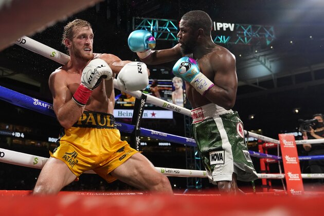 Floyd Mayweather, right, throws a punch at Logan Paul, left, during an exhibition boxing match at Hard Rock Stadium, Sunday, June 6, 2021, in Miami Gardens, Fla. (AP Photo/Lynne Sladky)