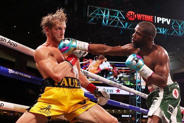 MIAMI GARDENS, FLORIDA - JUNE 06: Floyd Mayweather (R) punches Logan Paul during their contracted exhibition boxing match at Hard Rock Stadium on June 06, 2021 in Miami Gardens, Florida. (Photo by Cliff Hawkins/Getty Images)