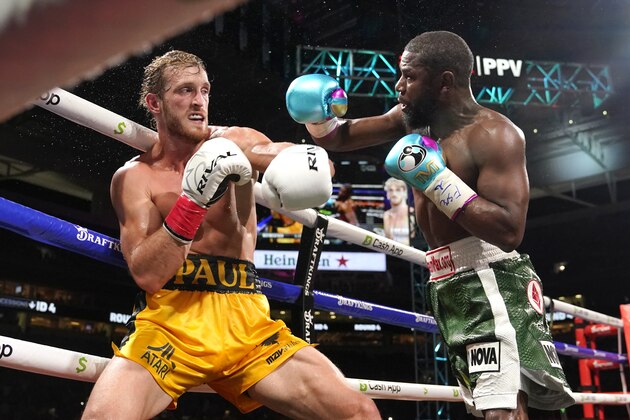 Logan Paul, left, and Floyd Mayweather, right, fight during an exhibition boxing match at Hard Rock Stadium, Sunday, June 6, 2021, in Miami Gardens, Fla. (AP Photo/Lynne Sladky)