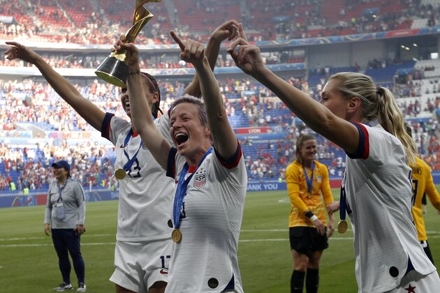 United States' Megan Rapinoe ,center, with Alex Morgan, left, and Allie Long, celebrate with the trophy after winning the Women's World Cup final soccer match between US and The Netherlands at the Stade de Lyon in Decines, outside Lyon, France, Sunday, July 7, 2019. (AP Photo/Claude Paris)