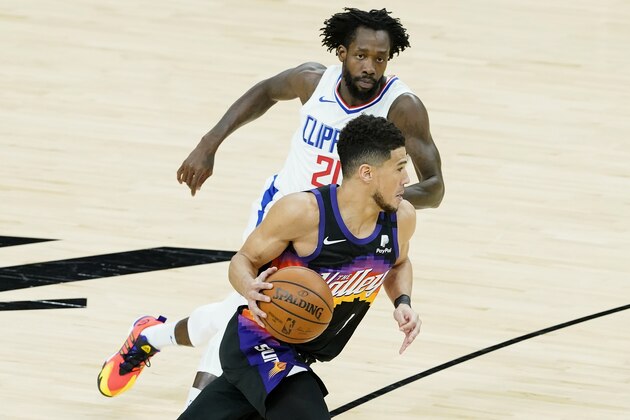 Phoenix Suns guard Devin Booker, bottom, dribbles against Los Angeles Clippers guard Patrick Beverley during the first half of Game 2 of the NBA basketball Western Conference Finals, Tuesday, June 22, 2021, in Phoenix. (AP Photo/Matt York)