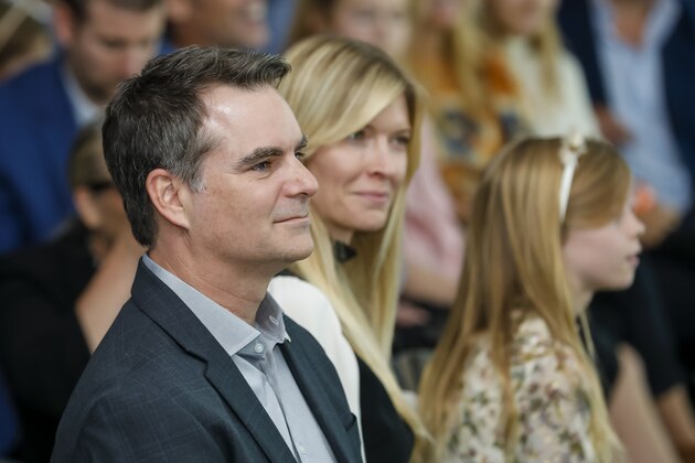 Former NASCAR champion Jeff Gordon sits next to Chandra Johnson and listens during the retirement press conference of his former teammate, NASCAR driver, Jimmie Johnson near Charlotte, N.C., Thursday, Nov. 21, 2019. (AP Photo/Bob Leverone)