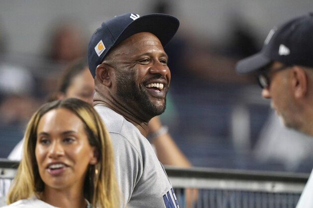 Retired New York Yankees pitcher CC Sabathia and his wife Amber walk through the stands during a baseball game between the New York Yankees and the Boston Red Sox, Sunday, June 6, 2021, at Yankee Stadium in New York. (AP Photo/Kathy Willens)