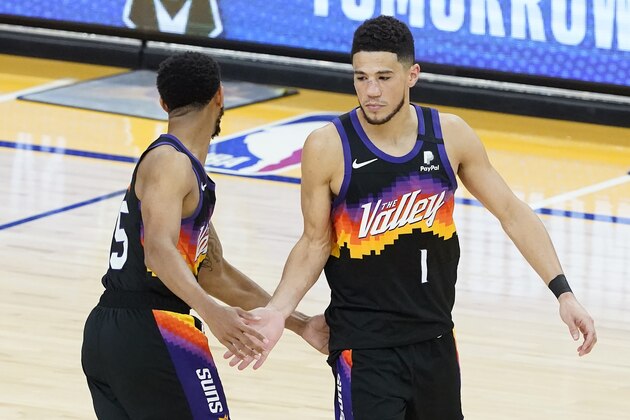 Phoenix Suns guard Devin Booker (1) is congratulated by forward Mikal Bridges during the second half of Game 2 of the NBA basketball Western Conference Finals against the Los Angeles Clippers, Tuesday, June 22, 2021, in Phoenix. (AP Photo/Matt York)