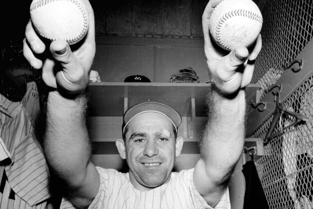 FILE - In this Aug. 20, 1959 file photo, New York Yankees catcher Yogi Berra  holds up two balls in the clubhouse after he hit two home runs in a 7-1 victory over Cleveland in New York. Berra, who filled baseball's record book as well as